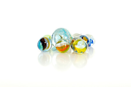 彩色玻璃球摄影照片_白色背景上的彩色弹珠