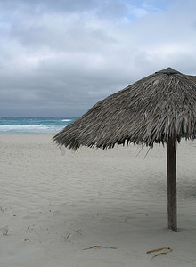 蓝绿色摄影照片_空荡荡的海滩上的阳伞