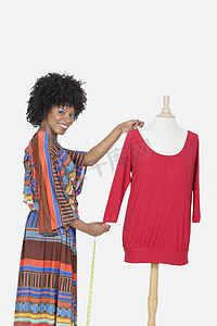 灰色背景下测量红色束腰外衣的非洲裔美国女设计师肖像