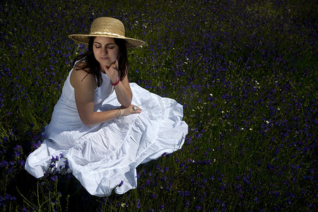 穿着白色连衣裙的美女在大自然中放松