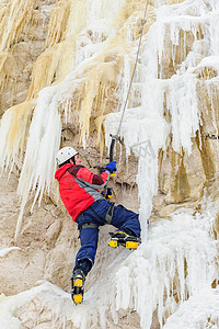 冰爪摄影照片_攀登冰的年轻人