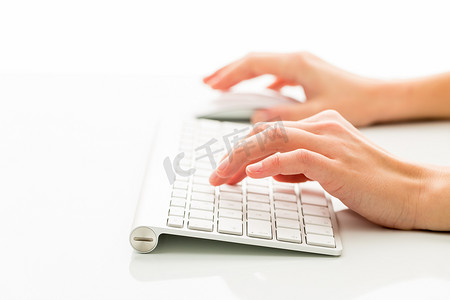 在白色背景下使用键盘的人的手