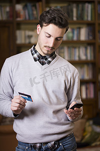 有魅力的年轻人在网上购物在手机上