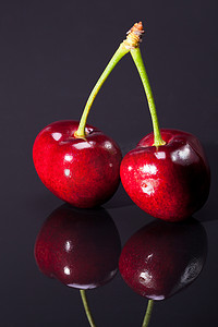 绿色食物插图摄影照片_深色背景中分离的成熟红樱桃果实