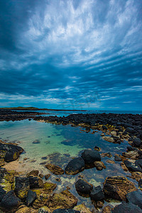 波波池摄影照片_多云天空中海洋火山岩池的黄昏