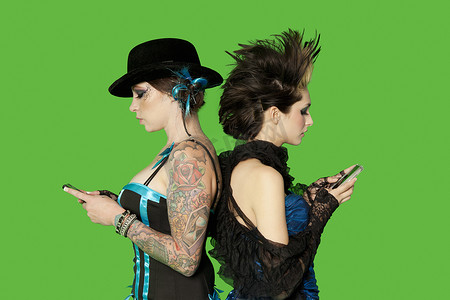 翻译结果朋克女性背靠背手持手机站在绿色背景下