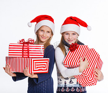 圣诞老人的帽子的两个女孩有礼物盒的