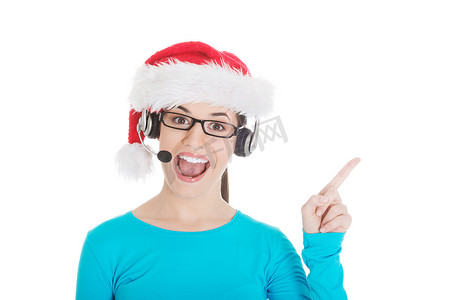 圣诞老人帽子和、话筒和耳机的年轻偶然妇女。
