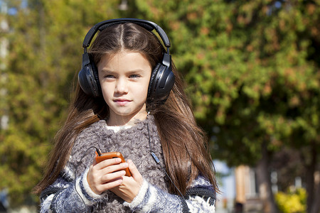 戴着耳机听音乐的漂亮小女孩