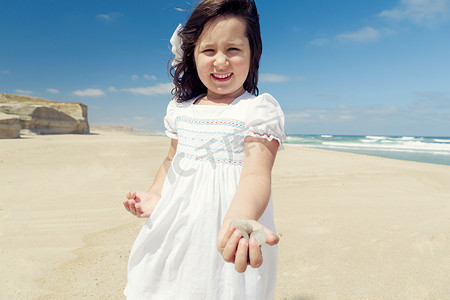 沙滩上拿着石头的女孩