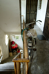 破旧小房子摄影照片_住宅楼小路上的破旧自行车