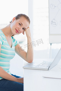 办公室年轻女性在笔记本电脑前微笑照片