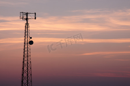 粉红色天空下的手机信号塔剪影