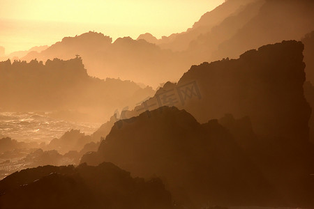 山和阳光摄影照片_日落岩石和海
