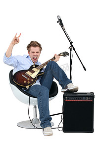 摇滚手势吉他摄影照片_有弹吉他的年轻人摇滚音乐