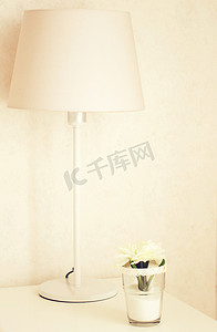 床边台灯和花卉（使用复古滤镜处理）的桌面装饰