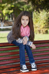 坐在长凳上的漂亮小女孩