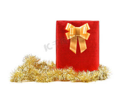 金斑点装饰摄影照片_有斑点和金色蝴蝶结的红色礼物盒。