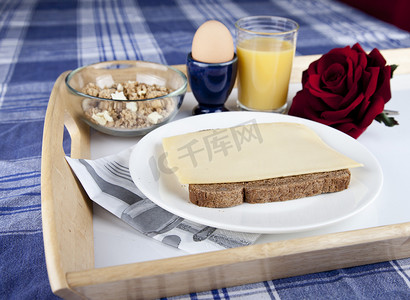 面包鸡蛋橙汁摄影照片_盘子上的早餐，包括面包、奶酪、鸡蛋、克鲁斯利和橙汁