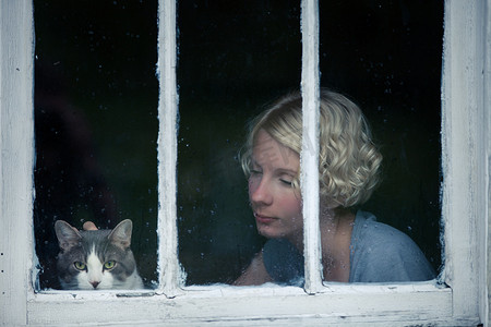 沮丧动物摄影照片_窗边看雨天的女人和猫