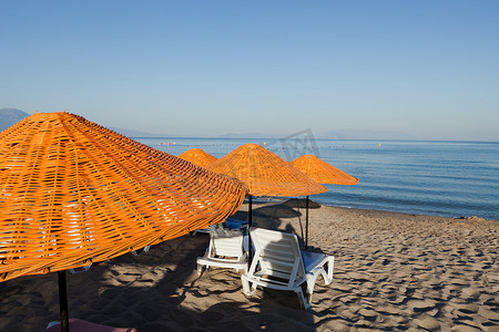 沙滩躺椅遮阳伞摄影照片_海边的沙滩躺椅和遮阳伞。