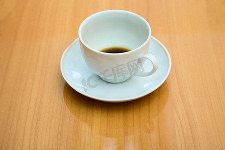 白色桌子桌子摄影照片_咖啡杯里的未喝完的咖啡