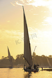 卢克索日落时在尼罗河上航行的三桅帆船