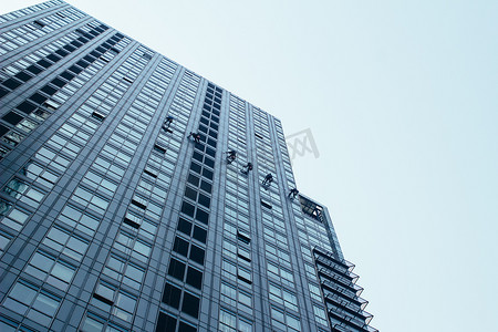 城市建筑玻璃摄影照片_清洁工正在清洁建筑玻璃