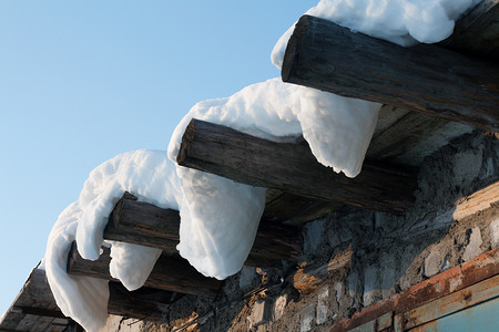 雪屋顶摄影照片_木屋屋顶下垂的雪3
