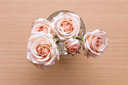 木桌上的粉色玫瑰花瓶