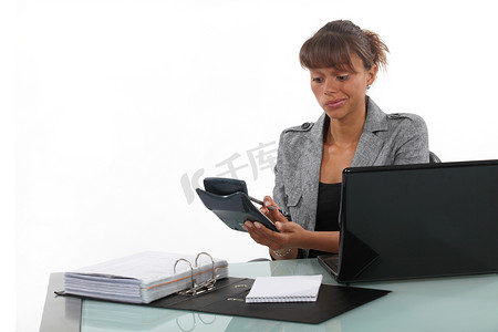 女商人在办公桌上使用计算器
