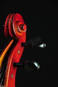 大提琴摄影照片_在黑色背景上的大提琴