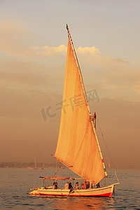 三桅小帆船摄影照片_Felucca 船在日落时在尼罗河上航行，卢克索