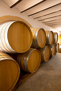 木桶摄影照片_在酿酒厂一排堆放的葡萄酒木橡木桶