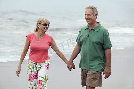情侣牵手走在沙滩上