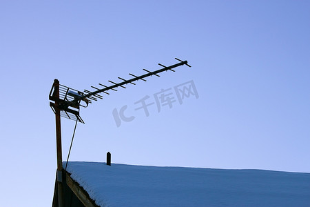 雪屋顶摄影照片_在多雪的屋顶的电视天线