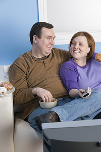 幸福的肥胖夫妇在家一起看电视
