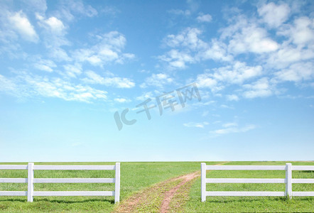 绿背景摄影照片_在绿草的白色篱芭与蓝天