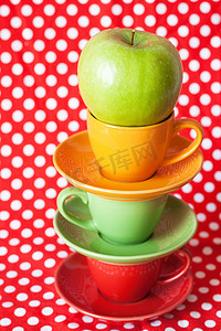 绿色苹果和红色背景的亮杯