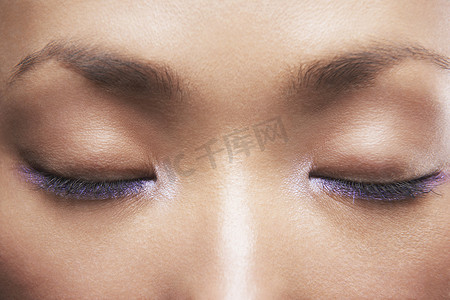 美丽女人的细节图像，有紫色眼线笔，闭着眼睛