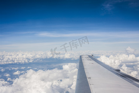 航空机翼摄影照片_在云层上方飞行的飞机的机翼。
