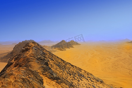 漫天黄沙摄影照片_雾中沙漠中的山脉和黄沙