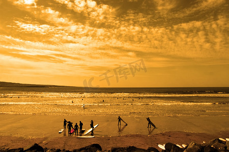 学生冲浪者光荣的日落海滩