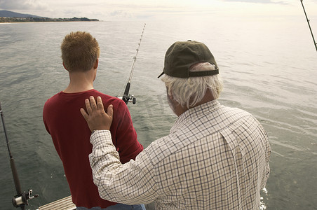 祖父摄影照片_祖父在游艇上钓鱼的男人的后视图