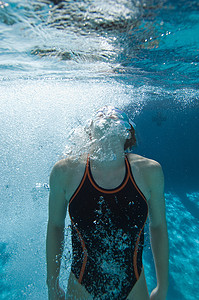 活跃的女潜水员在水下屏住呼吸游泳