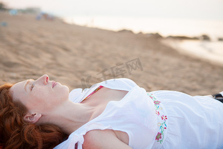 一束白光摄影照片_地中海沙滩上的孕妇白光照亮下
