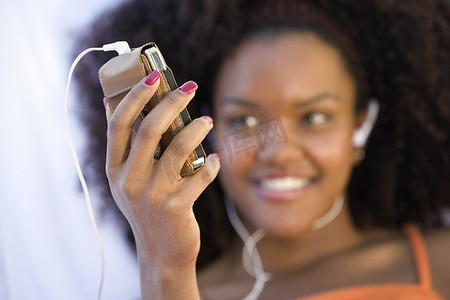 快乐的非洲裔美国女人通过手机听音乐