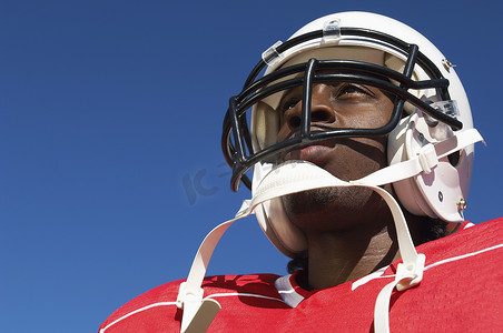 在清澈的蓝天上戴着头盔的美国足球运动员的特写镜头低角度视图