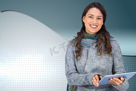 微笑模特穿着冬装手持平板电脑的合成图像