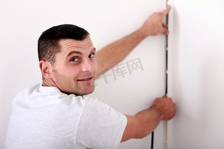 男人把电线固定在墙上